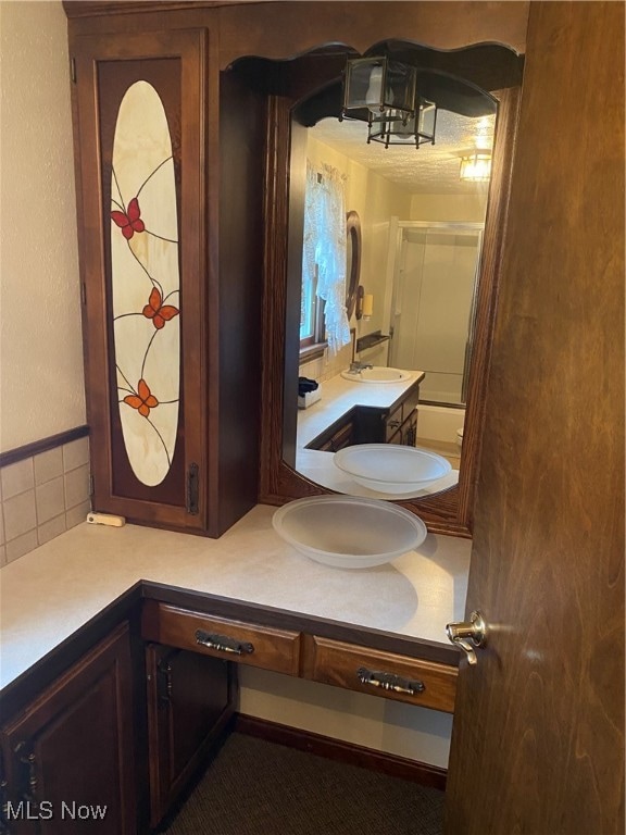 bathroom featuring vanity and backsplash