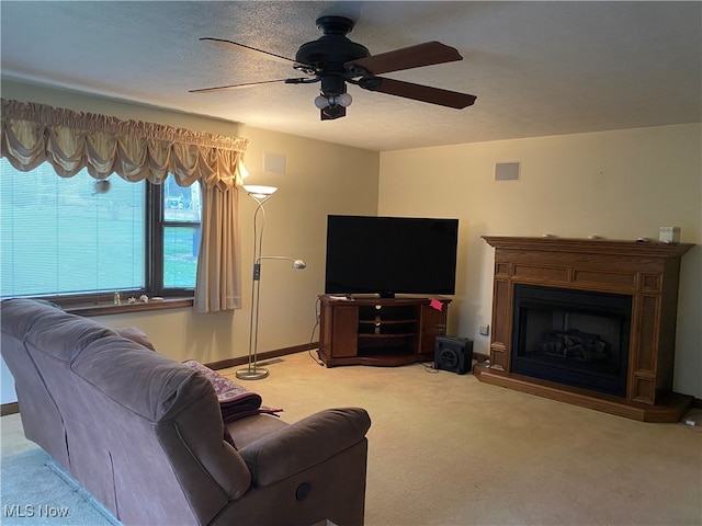 carpeted living room featuring ceiling fan and a textured ceiling