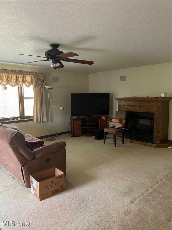 carpeted living room with a textured ceiling and ceiling fan