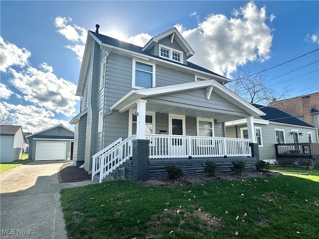 view of front of home with a garage, a front yard, covered porch, and an outdoor structure