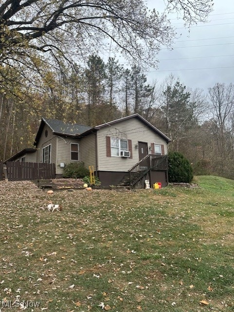 view of side of property featuring cooling unit and a yard