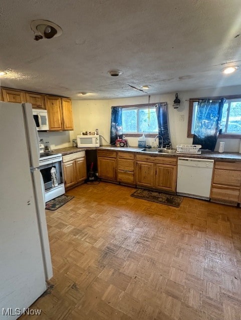 kitchen featuring a textured ceiling, plenty of natural light, sink, and white appliances