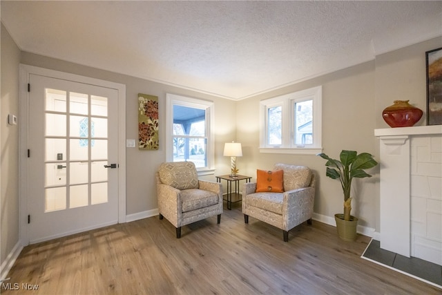 sitting room with hardwood / wood-style floors and a textured ceiling