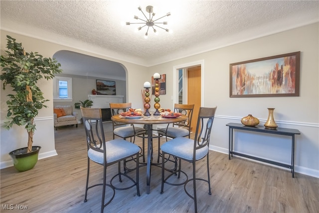 dining space featuring a textured ceiling and light hardwood / wood-style floors