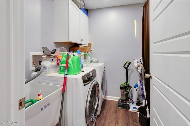 clothes washing area with dark hardwood / wood-style flooring, sink, cabinets, and washing machine and clothes dryer