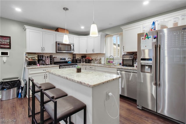 kitchen featuring white cabinets, sink, a kitchen island, and appliances with stainless steel finishes