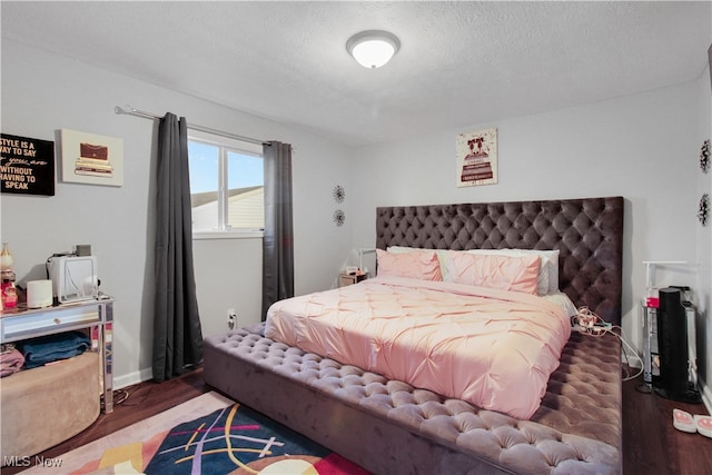 bedroom featuring wood-type flooring and a textured ceiling