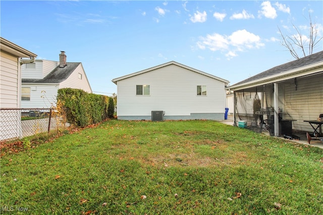 exterior space featuring a sunroom, cooling unit, and a yard