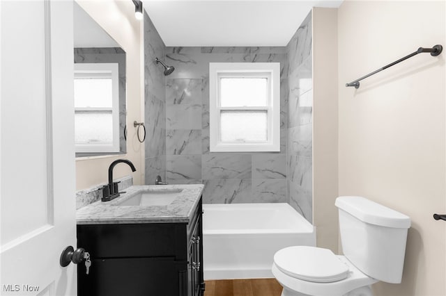 full bathroom with toilet, vanity, wood-type flooring, and tiled shower / bath