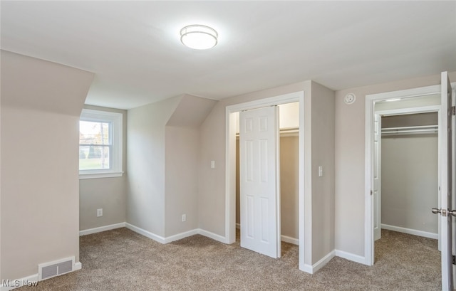 unfurnished bedroom featuring light colored carpet and a closet