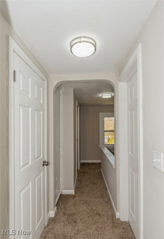 hallway featuring light colored carpet