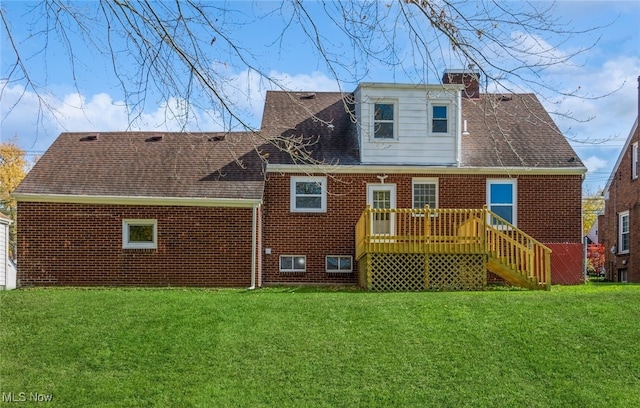 back of property with a lawn and a deck