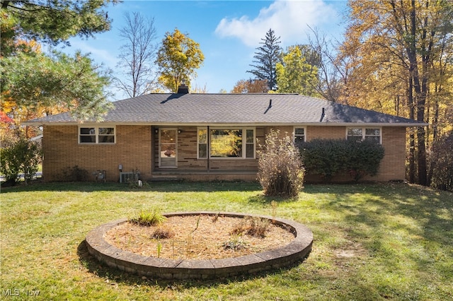 rear view of property featuring a lawn