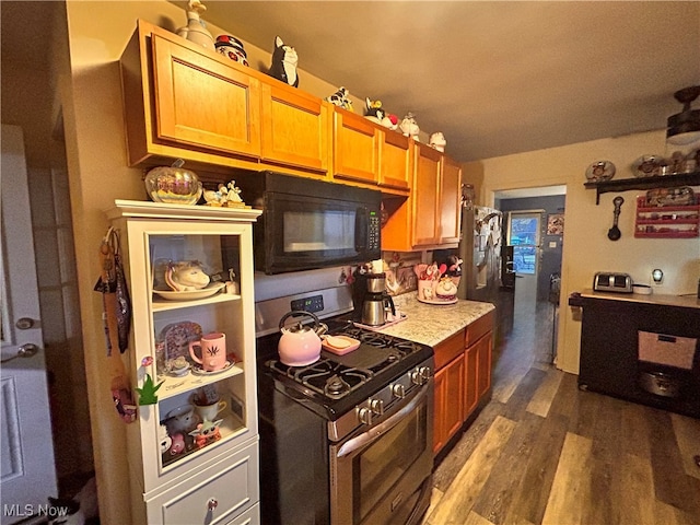 kitchen with stainless steel gas range and dark hardwood / wood-style floors