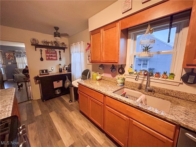 kitchen featuring light hardwood / wood-style floors, sink, and light stone counters