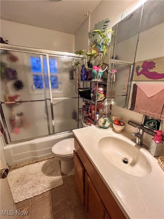 full bathroom with toilet, vanity, tile patterned flooring, and shower / bath combination with glass door