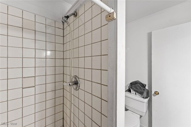 bathroom with toilet and tiled shower