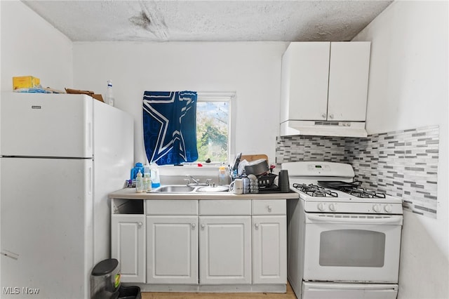 kitchen with white cabinets, a textured ceiling, sink, and white appliances