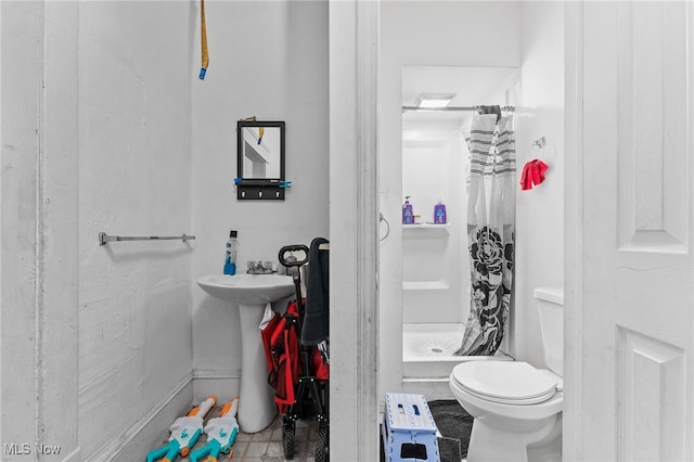 bathroom with walk in shower, toilet, and tile patterned floors