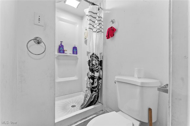 bathroom featuring a shower with shower curtain and toilet