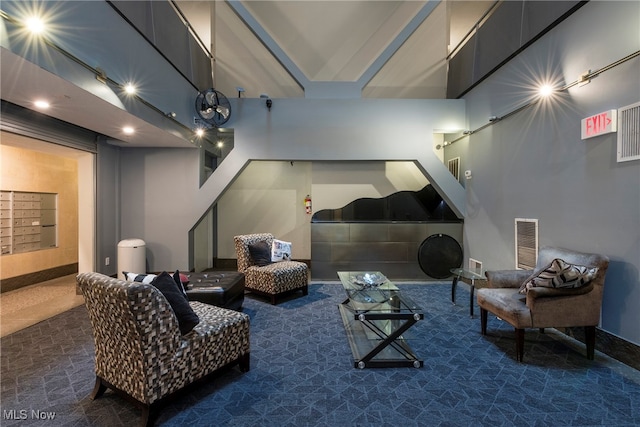 cinema room featuring mail boxes and dark carpet