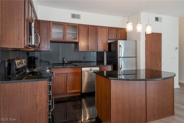 kitchen with a center island, decorative backsplash, sink, dark hardwood / wood-style floors, and appliances with stainless steel finishes