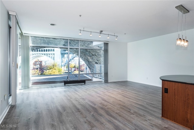 unfurnished living room featuring expansive windows and dark hardwood / wood-style floors