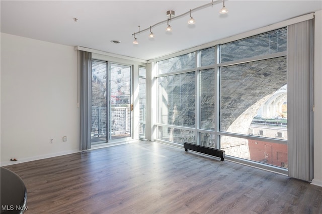 empty room featuring wood-type flooring and floor to ceiling windows