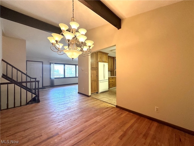 unfurnished dining area featuring light wood-type flooring, a notable chandelier, and beam ceiling