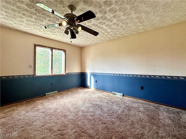 carpeted empty room with a textured ceiling and ceiling fan