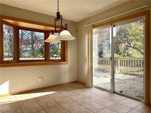 unfurnished dining area with a textured ceiling and light tile patterned floors