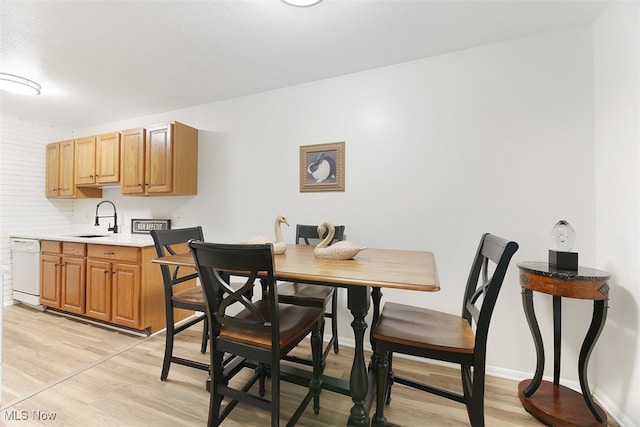 dining room featuring sink and light hardwood / wood-style floors