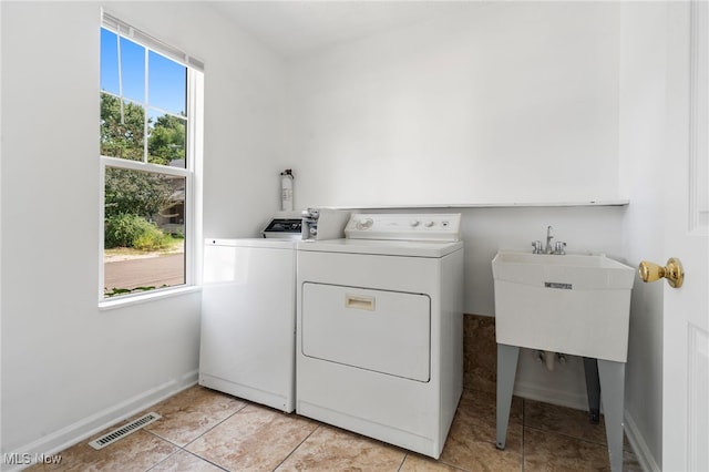 washroom featuring sink, light tile patterned floors, and washer and dryer