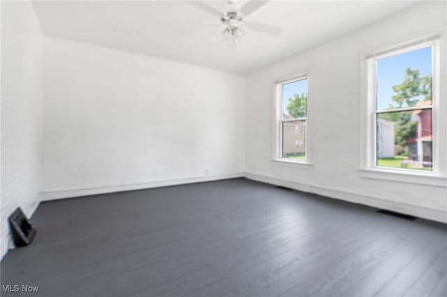 empty room with ceiling fan and dark hardwood / wood-style flooring