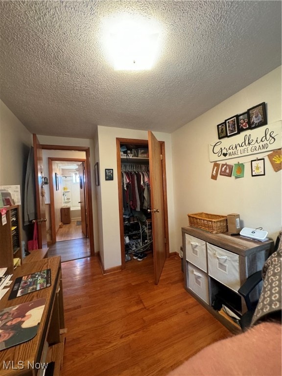 bedroom featuring a textured ceiling, dark hardwood / wood-style floors, and a closet