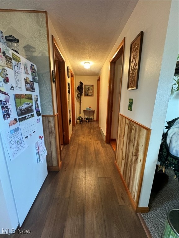 hall featuring dark wood-type flooring and a textured ceiling