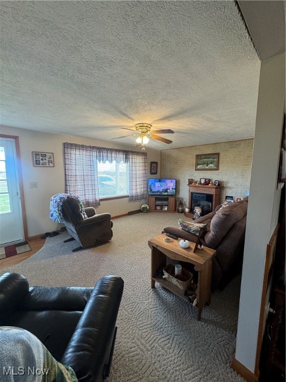 carpeted living room with a textured ceiling and ceiling fan