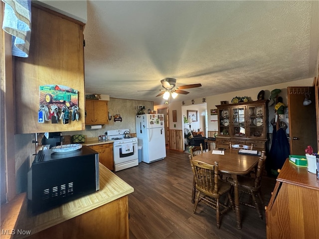 kitchen featuring dark wood-type flooring, white appliances, a textured ceiling, and ceiling fan