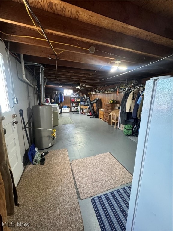 basement featuring gas water heater and white fridge