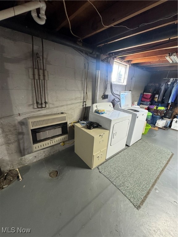 basement featuring heating unit and washing machine and clothes dryer