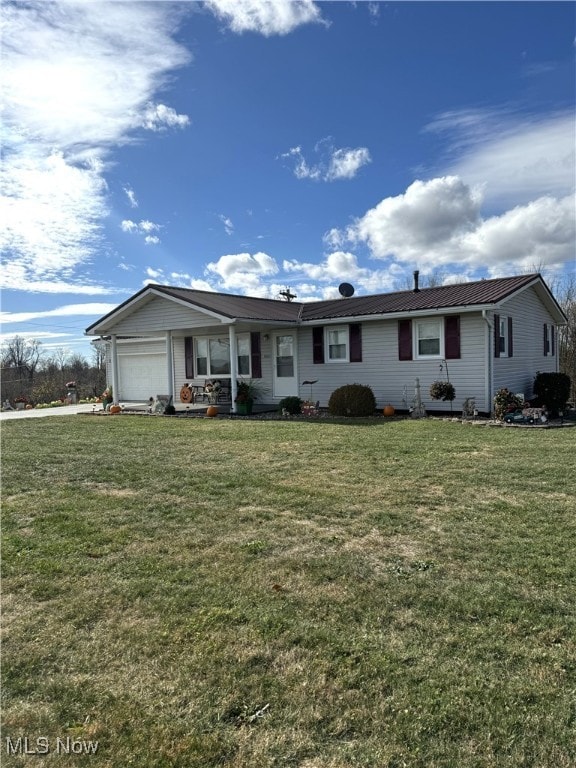 ranch-style house featuring a garage and a front lawn