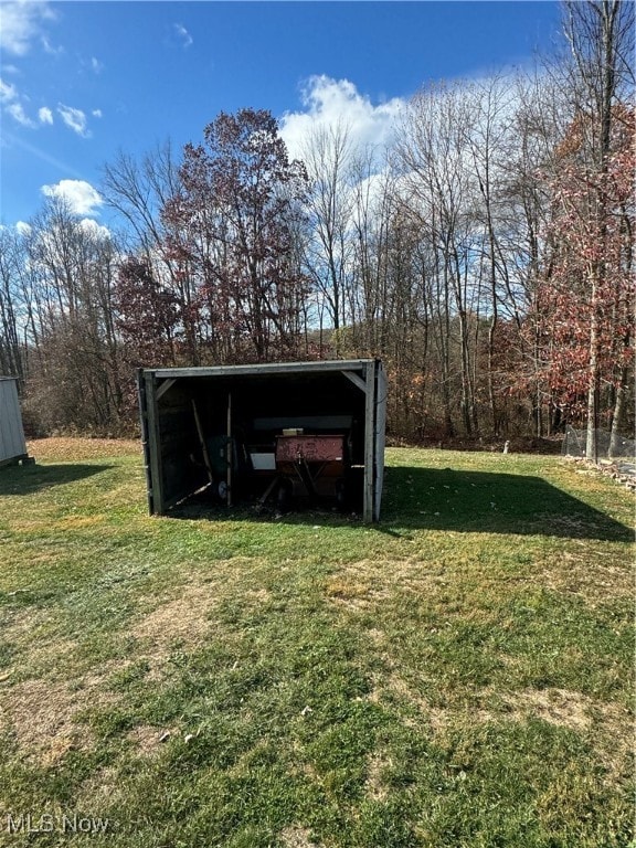 view of outbuilding featuring a yard and a carport