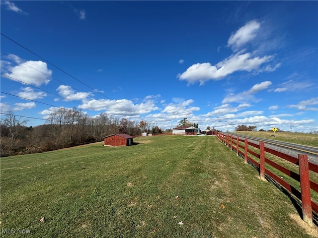 view of yard with a storage shed and a rural view