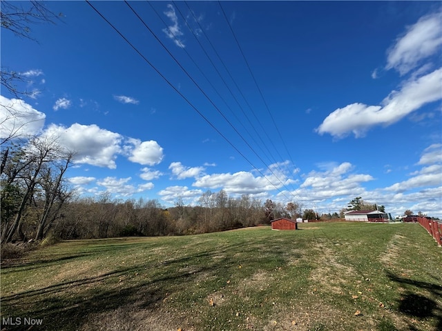 view of yard featuring a rural view and an outdoor structure