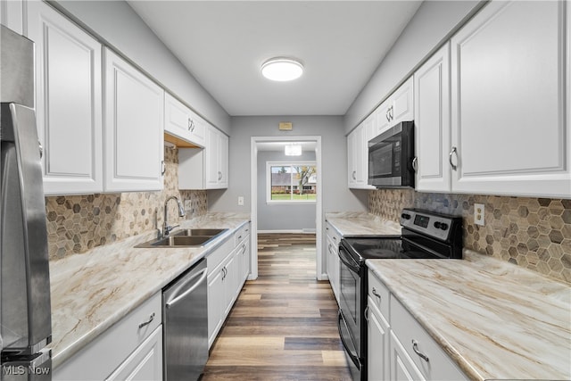 kitchen featuring stainless steel appliances, wood-type flooring, white cabinets, decorative backsplash, and sink