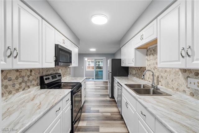 kitchen with white cabinets, stainless steel appliances, light hardwood / wood-style floors, and sink