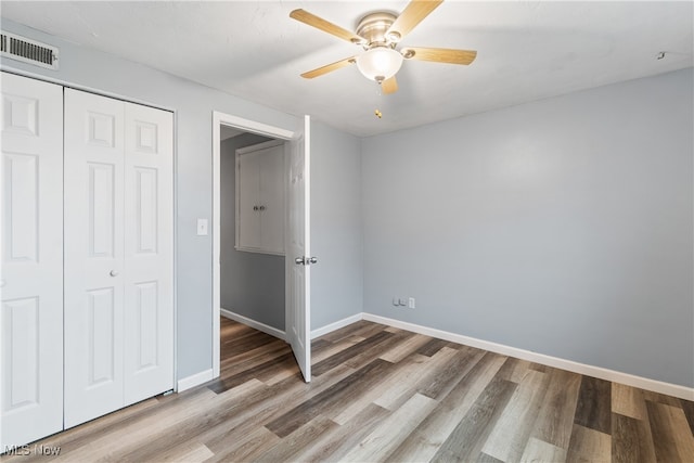 unfurnished bedroom featuring a closet, hardwood / wood-style floors, and ceiling fan