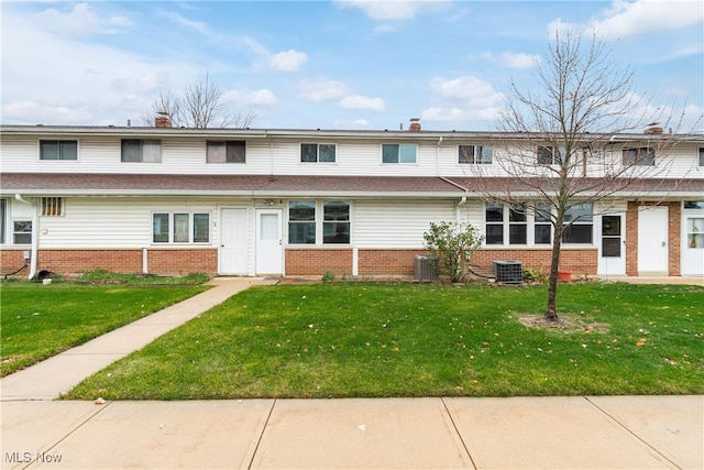 view of property with central AC unit, a front yard, and a sunroom