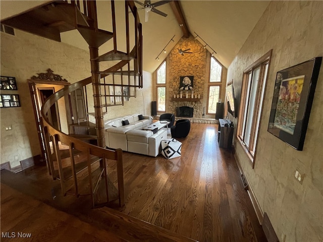 living room featuring ceiling fan, dark hardwood / wood-style floors, beam ceiling, high vaulted ceiling, and a fireplace