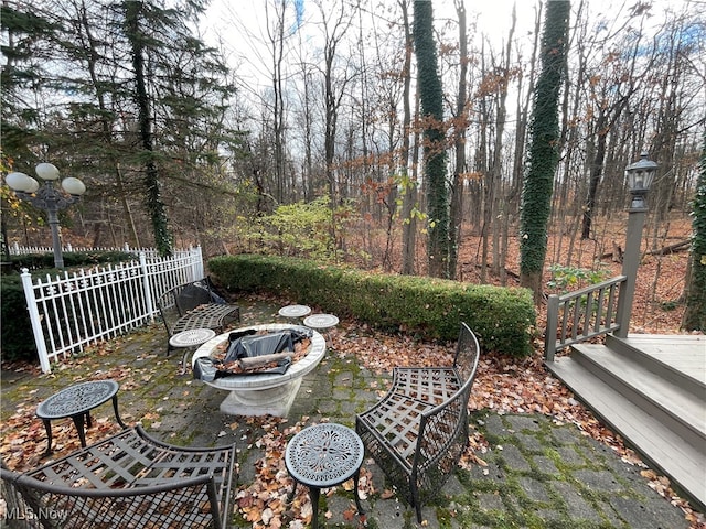 view of patio featuring a wooden deck and a fire pit